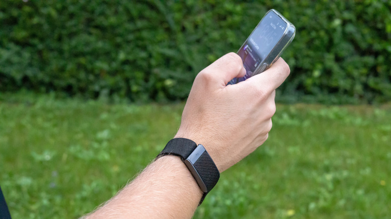 An iPhone user wearing a Whoop.