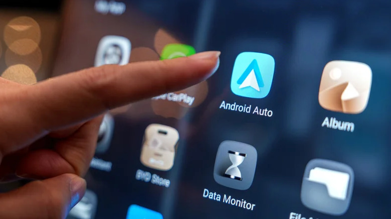 Person reading out towards the Android Auto app on a car's infotainment system.