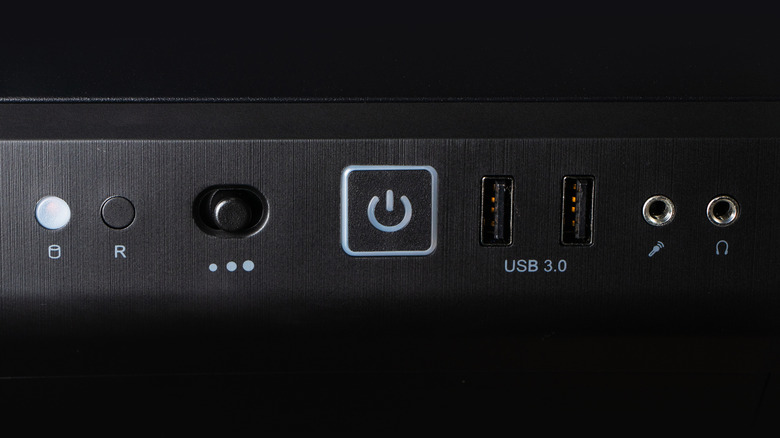 A desktop PC's power button, alongside various ports.