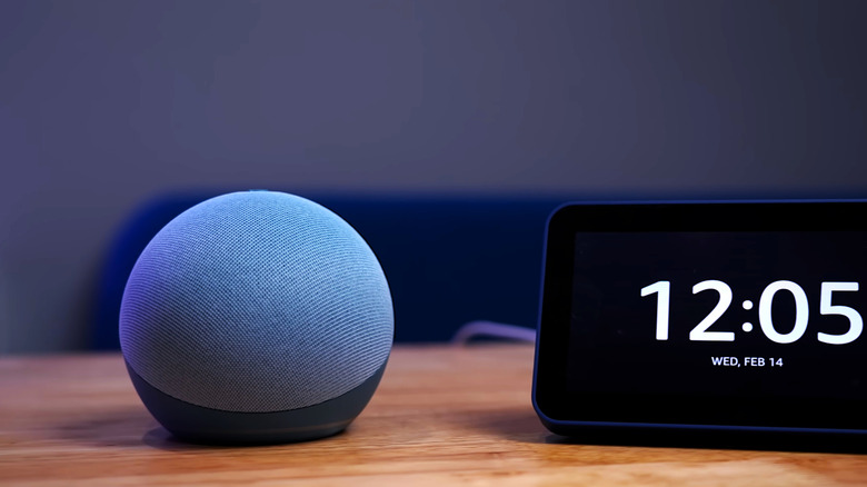 Echo Dot speaker sitting next to a digital clock display.